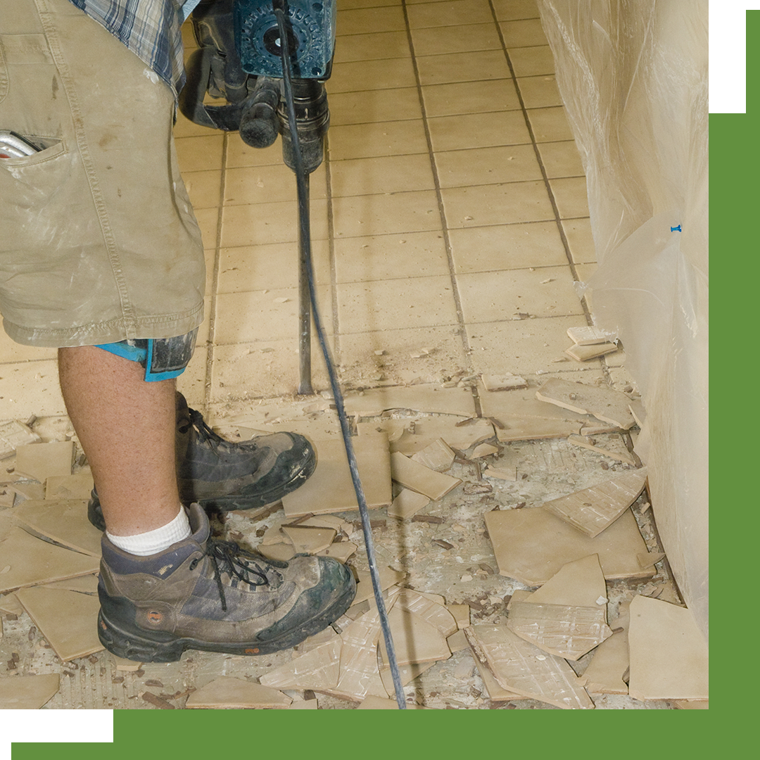 Image of a worker breaking up tile flooring